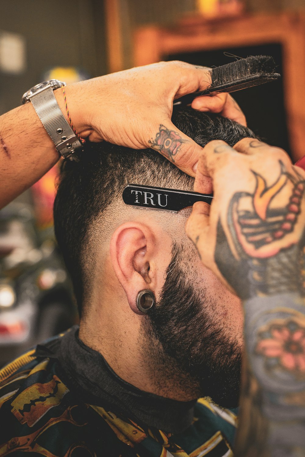Barbero recortando el cabello de un cliente con navaja, foto de referencia
