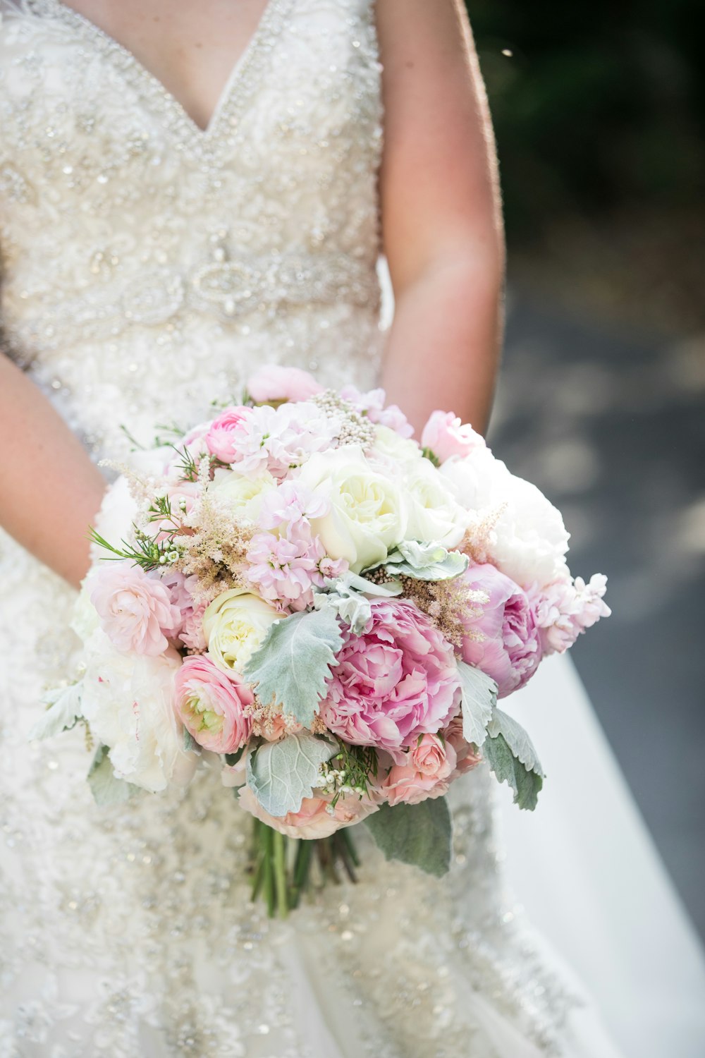 Novia sosteniendo un ramo de flores rosas y blancas