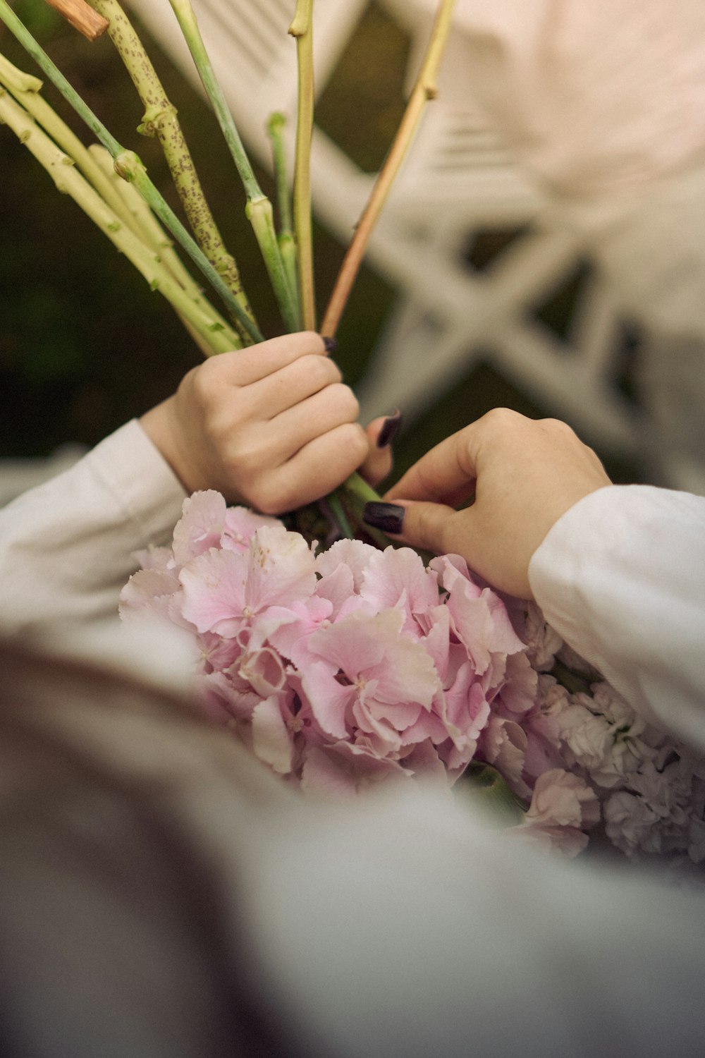 Manos preparando un ramo de hortensias rosas en el taller de Catch Flower Studio